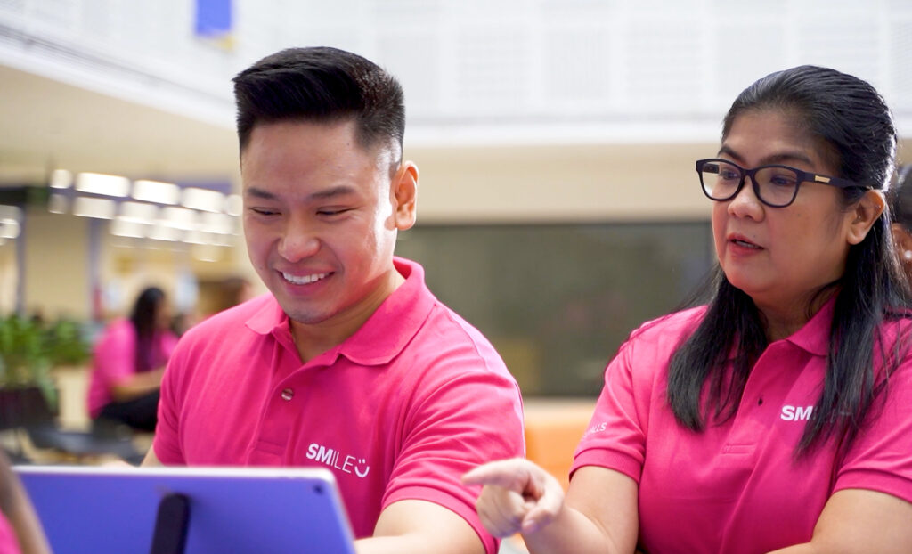 An SM leader guides a colleague, reflecting SM Prime’s commitment to professional growth and talent development.