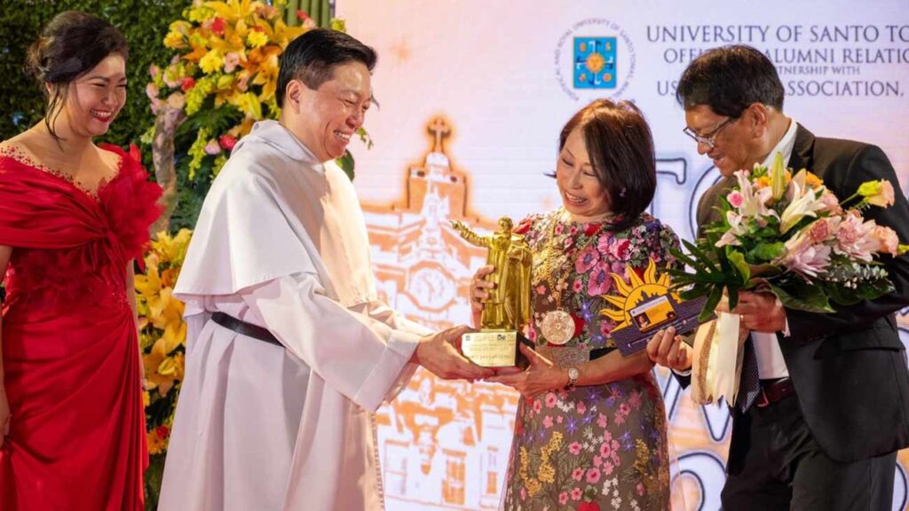 Tan Caktiong (third from left) is awarded by Fr. Richard Ang, O.P. UST Rector; Dwight Ramos, president of the UST Alumni Association, Inc.; and Joreen Rocamora,