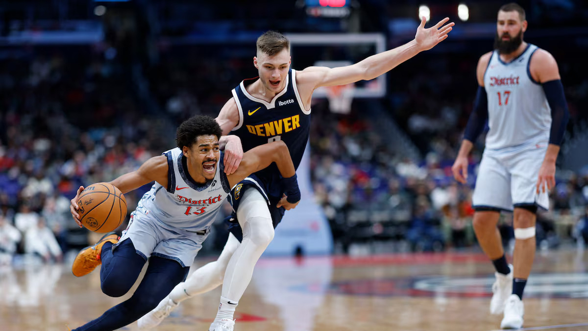GETTING AWAY: Wizards guard Jordan Poole (13) drives to the basket as off Nuggets counterpart Christian Braun (0) in yesterday’s game.