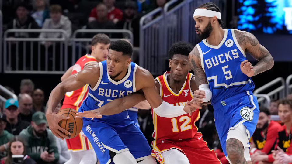 HUSTLE: Bucks star Giannis Antetokounmpo (34) and Hawks forward De’Andre Hunter (12) battle for possession in yesterday’s game.