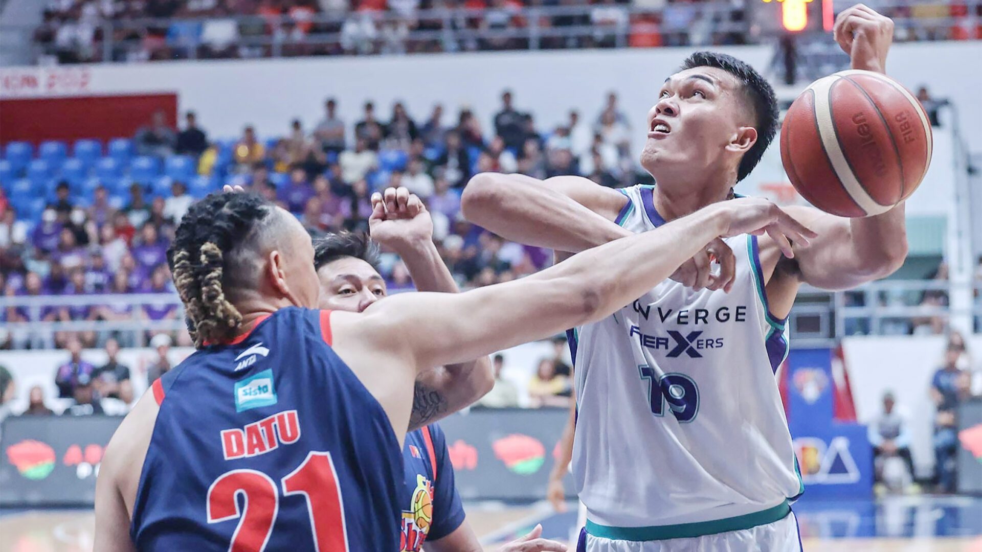 HACKED: Converge rookie big man Justine Baltazar gets fouled by Rain or Shine’s Keith Datu in last night’s game.