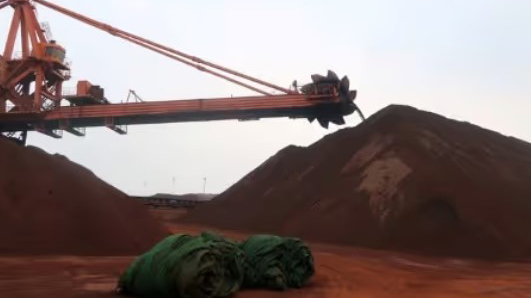 A machine works on blending the iron ore at Dalian Port, Liaoning province, China.  (Reuters Photo)