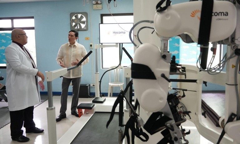 Dr. Raul Cembrano (left) explains the mechanics and benefits of the Lokomat robot-assisted therapy ma-chine to Okada Foundation, Inc. President James Lorenzana (right)