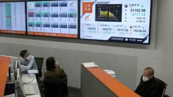 Employees watch monitors displaying Japan's Nikkei share average at Nagoya Stock Exchange in Nagoya, Japan. (Reuters Photo)