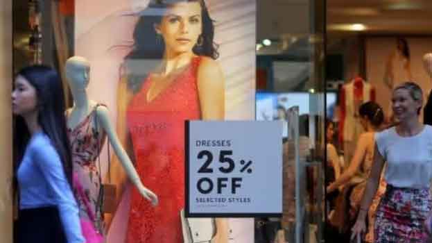 A customer walks out of a women's clothing store displaying dresses and a sale sign in the window in central Sydney, Australia. (Reuters Photo)